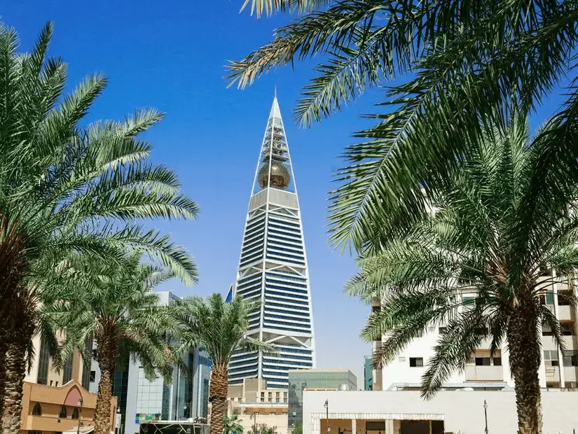 A wide view of Al Faisaliyah Center framed by palm-lined streets.