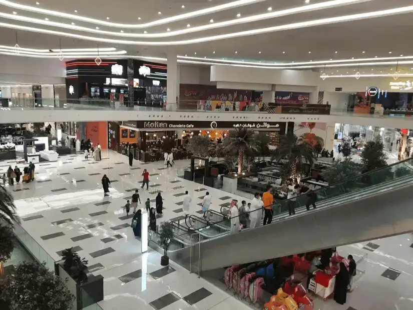 A view of the food court in a large mall with bright lights and busy shoppers.