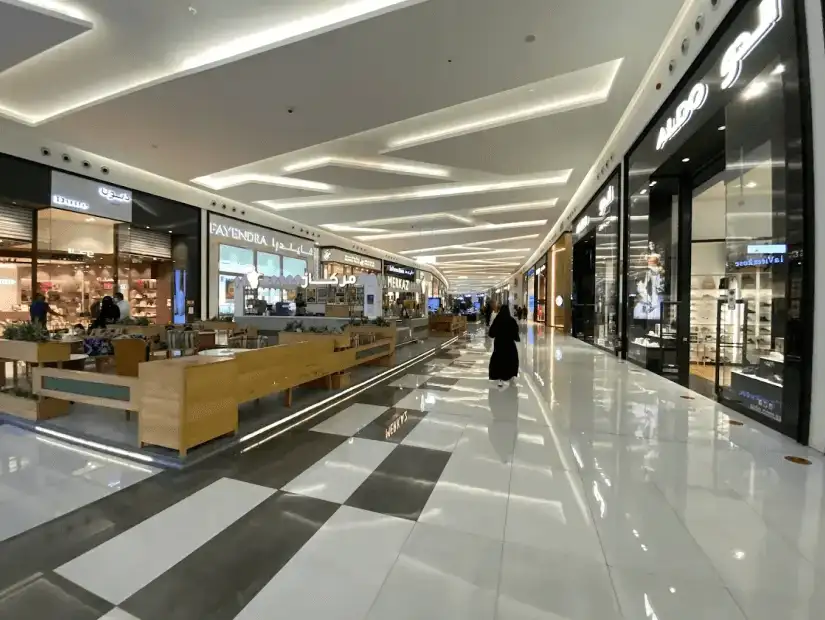 An indoor shopping mall with sleek, modern stores and spacious walkways.