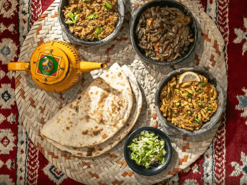 A traditional Yemeni feast featuring a variety of spiced dishes with bread and salad.