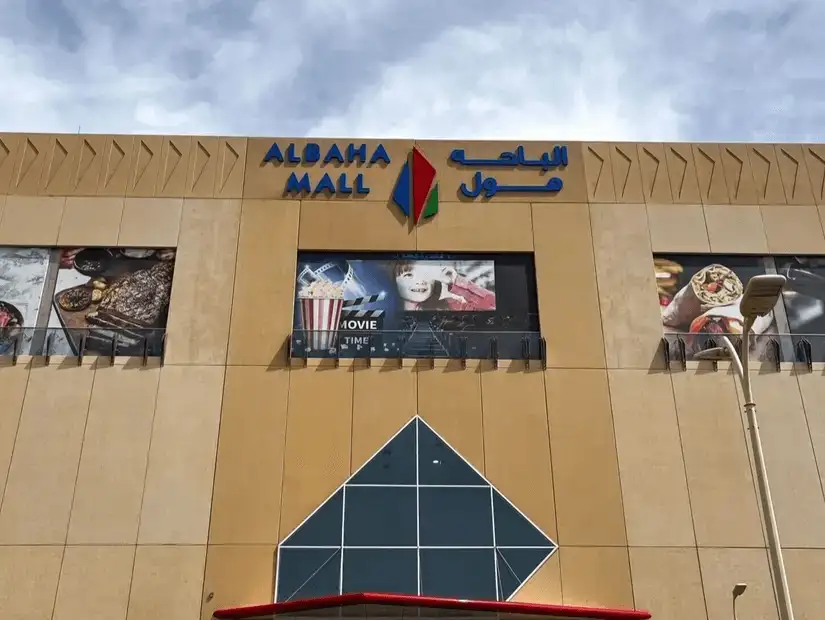 Al-Baha Mall exterior with colorful advertisements.