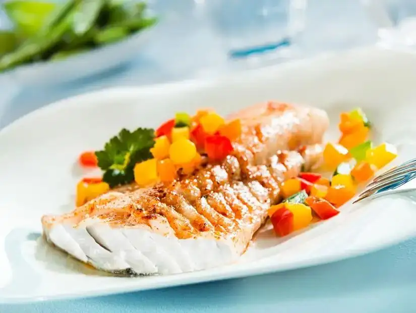 Perfectly grilled salmon served with a colorful mix of diced vegetables.