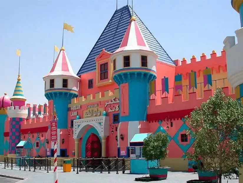 A brightly colored castle stands tall, marking the entrance to a fun amusement park.