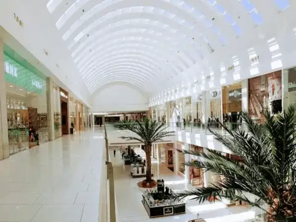 Bright and spacious interior of a mall featuring a long vaulted skylight.