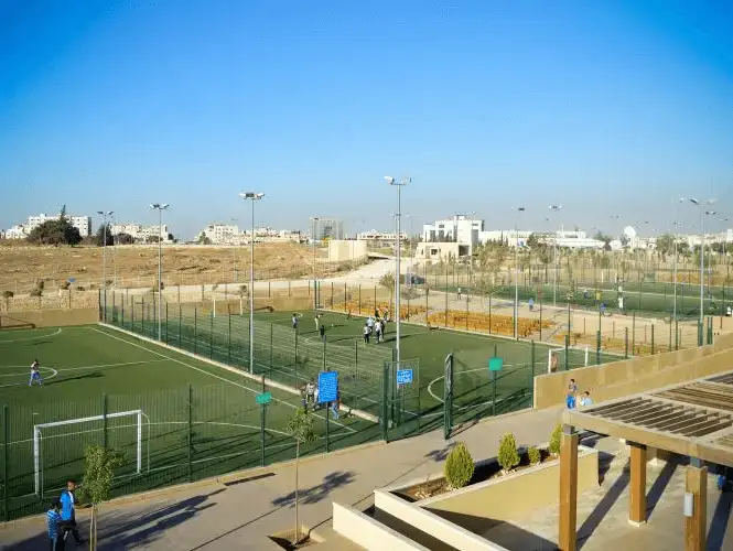 A vibrant sports complex bustling with activity under a clear blue sky.