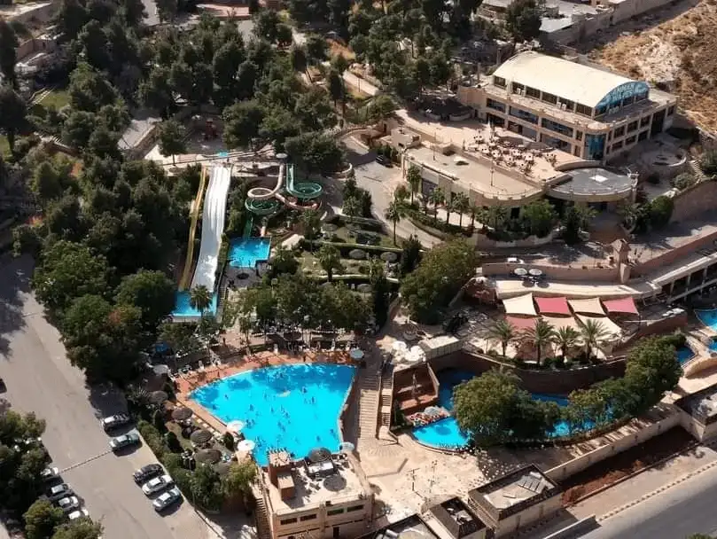 Aerial view of a vibrant water park nestled among greenery, offering refreshment and fun.