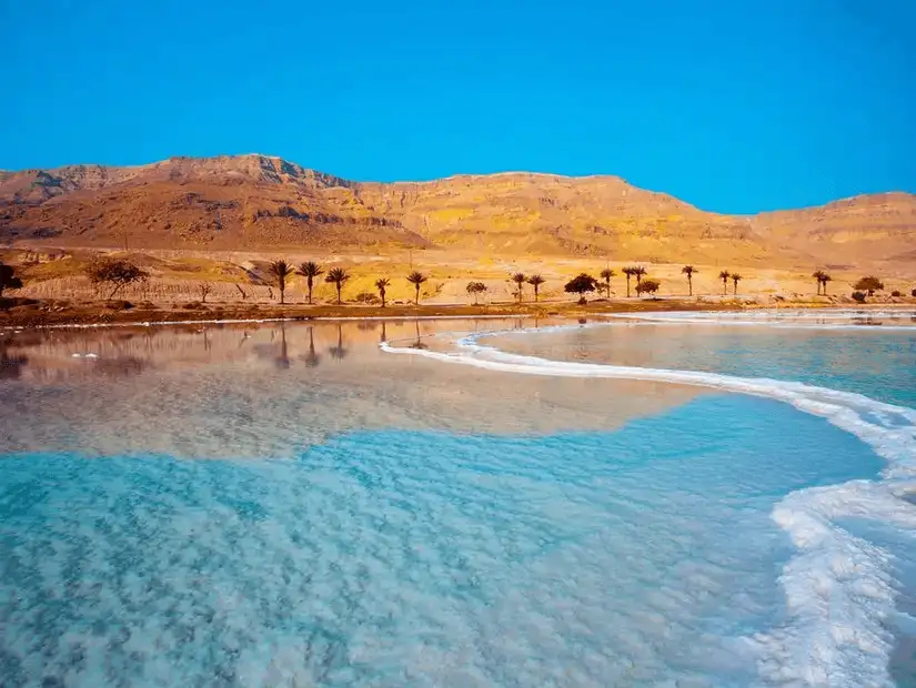 Mirrored beauty of a natural salt lake set against a rocky desert backdrop.