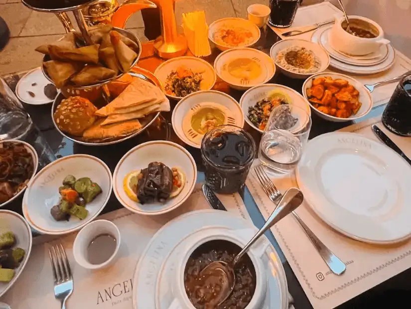 A lavish spread of appetizers including stuffed vine leaves, grilled meats, and a variety of dips, ready for a rich Middle Eastern meal.
