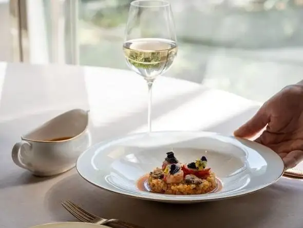 A delicate appetizer served with a glass of white wine to begin a luxurious dining experience.