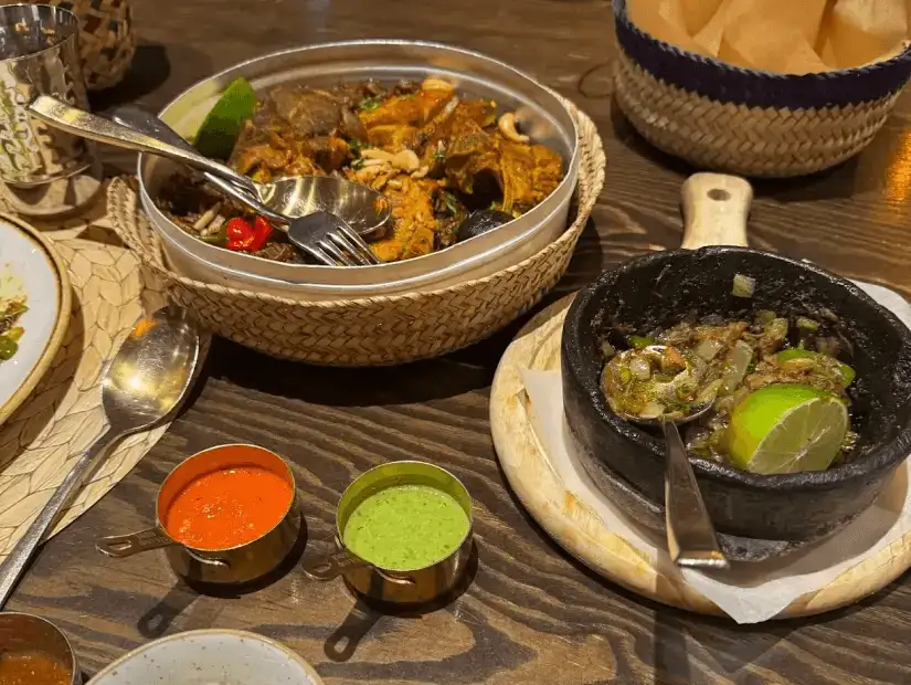 A spicy and aromatic plate featuring tender meat with fresh sauces and lime.