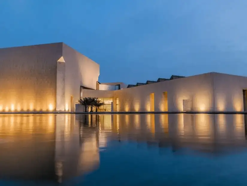 The Bahrain National Museum at twilight, reflecting beautifully on the water.