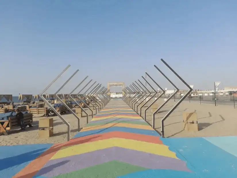 Colorful path leading to a vibrant beach area under a clear blue sky.