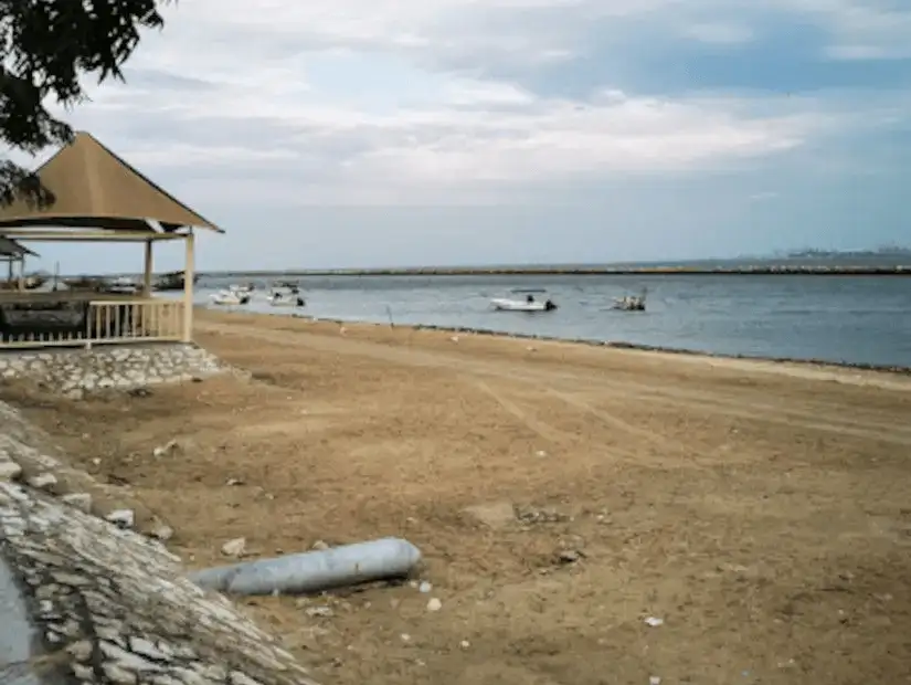 A rustic beach area with boats anchored near the shore.