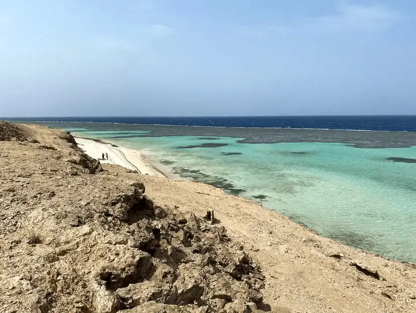 A tranquil beach view showing a clear horizon and calm sea.