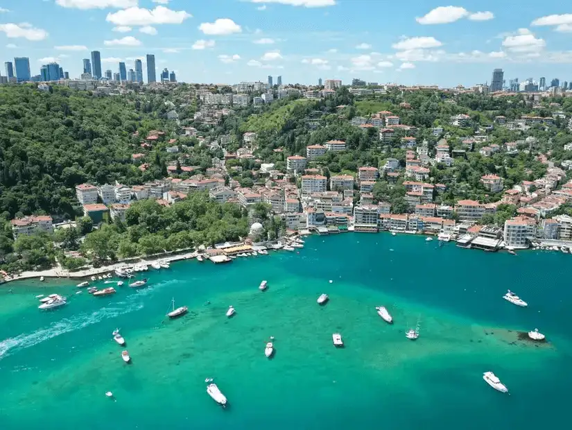 A beautiful bay area with clear turquoise water, surrounded by residential buildings and boats.