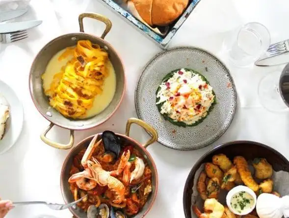 A family-style spread of various seafood dishes, ideal for sharing at a gathering.