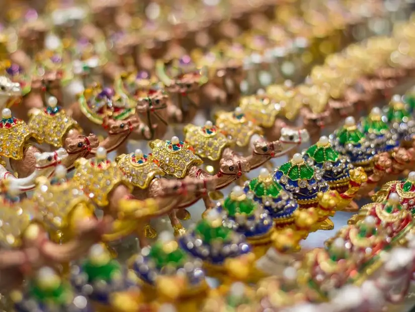 Rows of ornate camel figurines, each adorned with colorful gems.