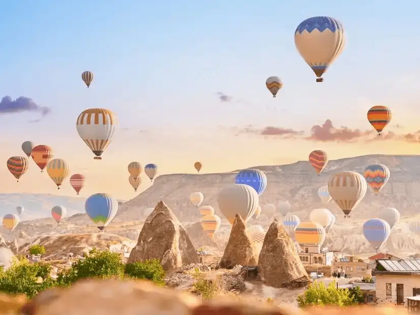 Hot air balloons soaring over the unique rock formations of Cappadocia at sunrise.