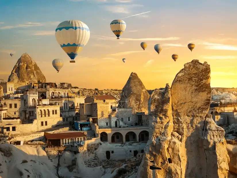 Hot air balloons floating above the stunning rock formations of Cappadocia at sunrise.