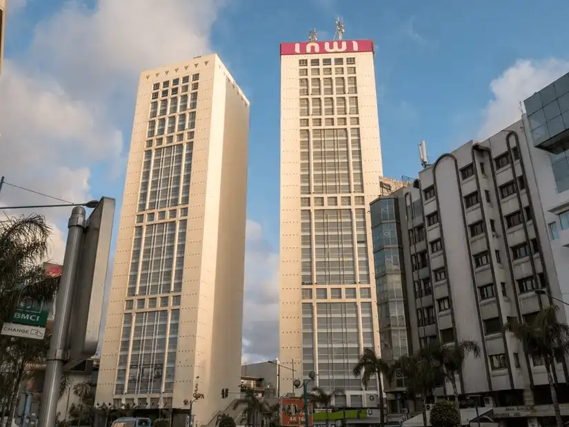 Twin towers of Casablanca Twin Center against a cloudy sky.