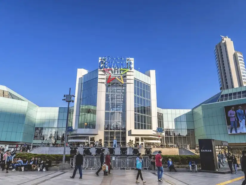 Bustling with shoppers, a modern glass-fronted shopping mall welcomes visitors.