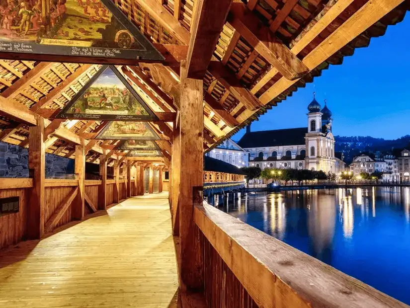 Historic Chapel Bridge in Lucerne illuminated at night.