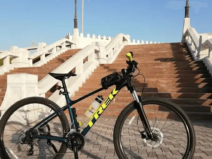 A bicycle parked near a white staircase at the Corniche, ready for an adventure.