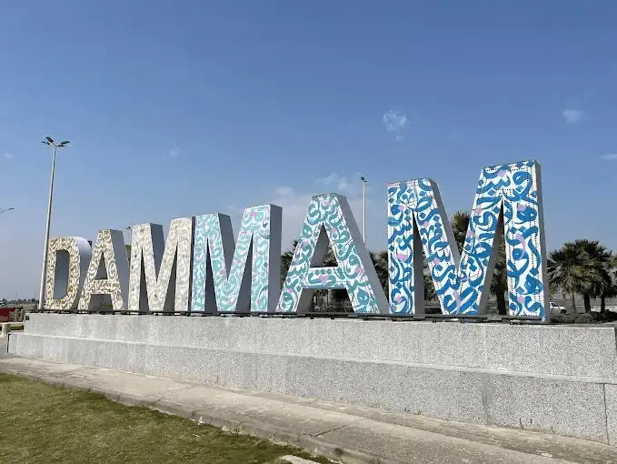 A colorful sign spelling out "DAMMAM" at the Corniche, standing out against the sky.