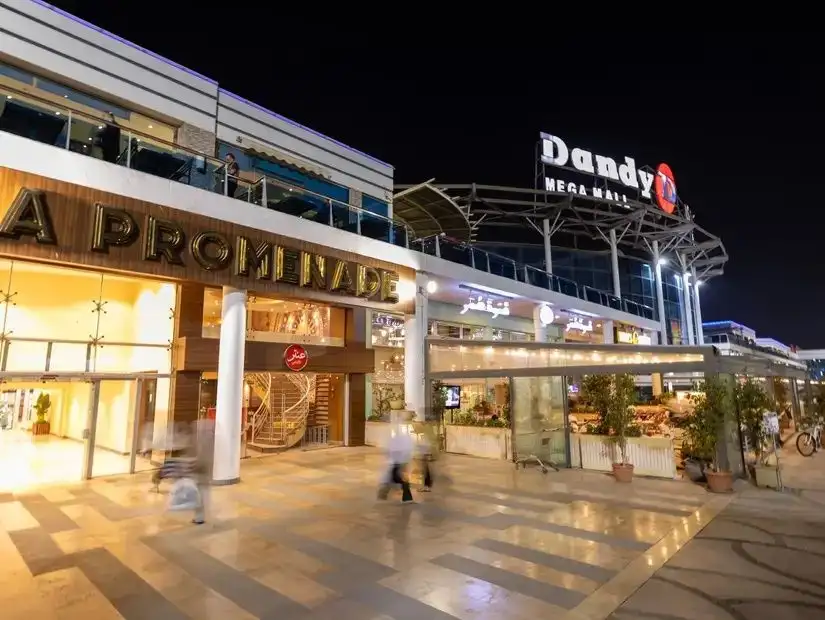 Dandy Mega Mall, showcasing its grand entrance and well-lit pathways during nighttime.