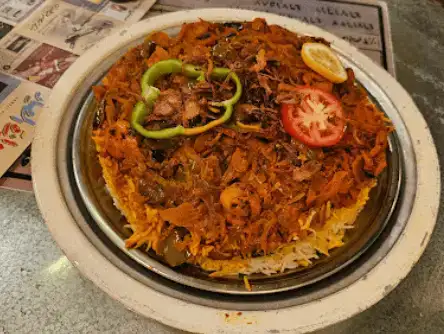 A traditional Arabic rice and seafood dish, topped with caramelized onions and fresh herbs.