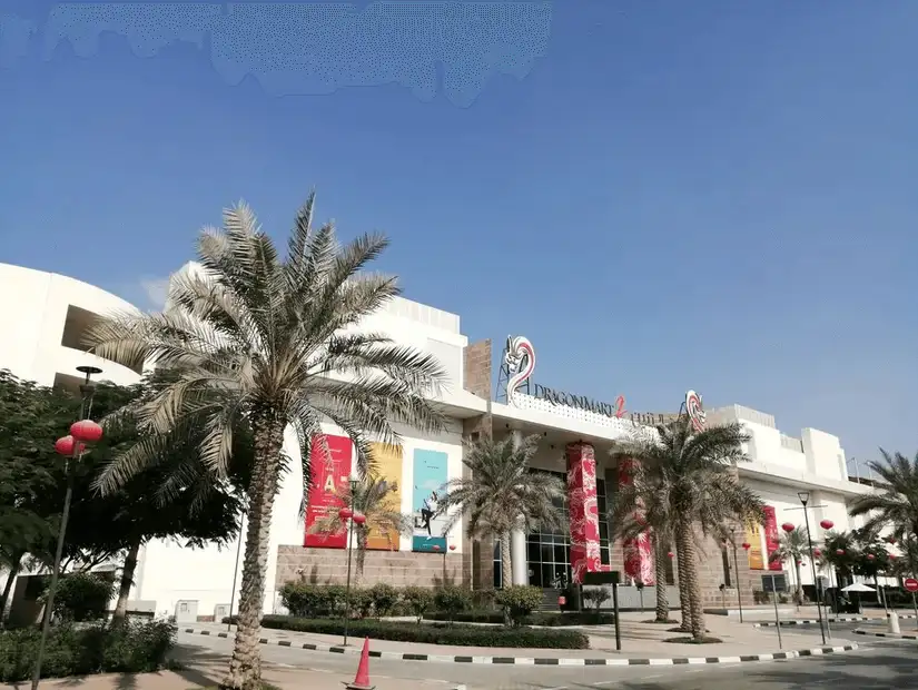 The main entrance of Dragon Mart, with its bold red accents and palm-lined path.