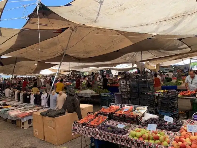 Fethiye's bustling local bazaar, filled with colorful goods, clothing, and fresh produce.