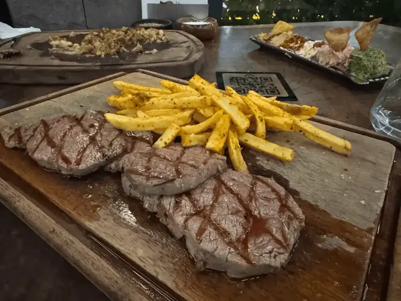 A well-grilled steak accompanied by crispy fries and flavorful side dishes.