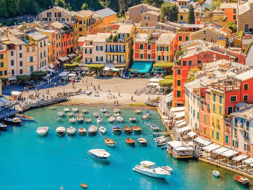 The charming waterfront of Genoa, where boats and yachts moor against a backdrop of pastel-colored buildings.