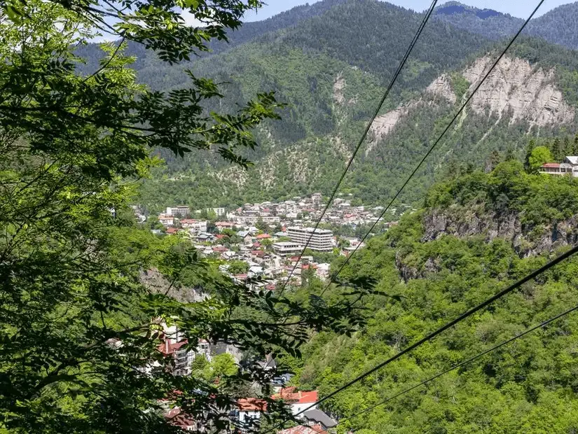 A peaceful valley town surrounded by steep, forested mountains.