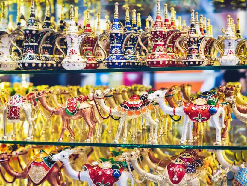 A variety of dazzling, bejeweled camels and teapots at a souvenir shop.