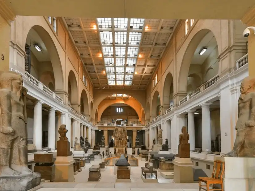 The impressive interior of the Grand Egyptian Museum, featuring large statues and historical artifacts.