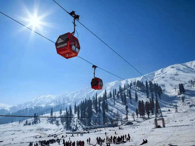 A breathtaking view of snow-covered mountains and a cable car crossing a winter landscape.