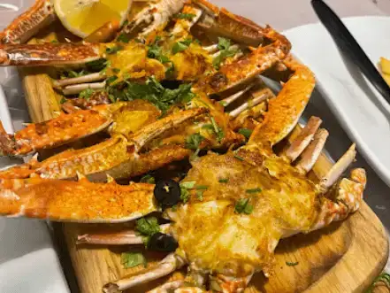 Crab platter with various dips, showcasing the fresh catch cooked in aromatic spices.