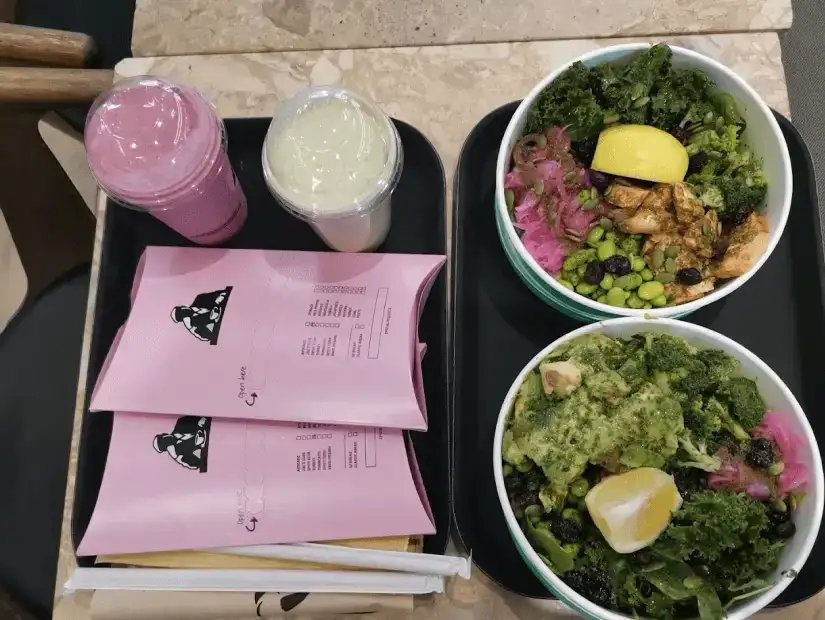 A vibrant display of fresh juices and bowls of healthy salads from Joe & The Juice, with smoothies and greens ready to enjoy.