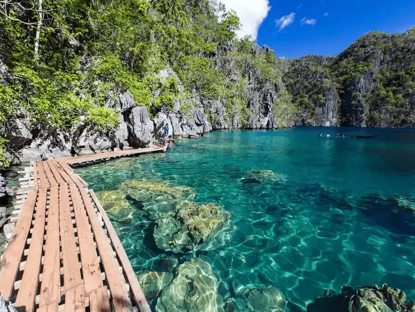 Kayangan Lake’s clear waters and rocky cliffs.