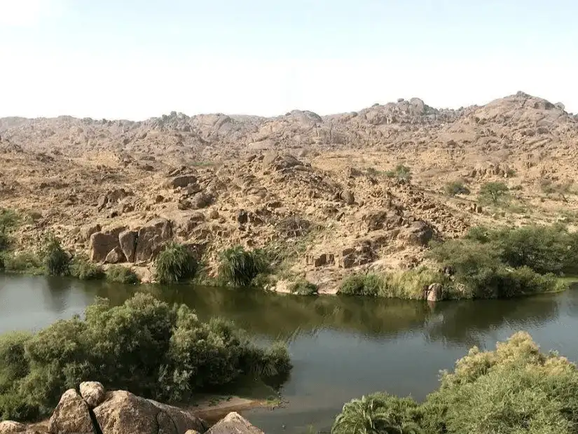 A serene river flowing through a rocky, mountainous terrain.