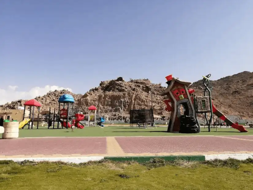 A colorful playground set against a rocky landscape.