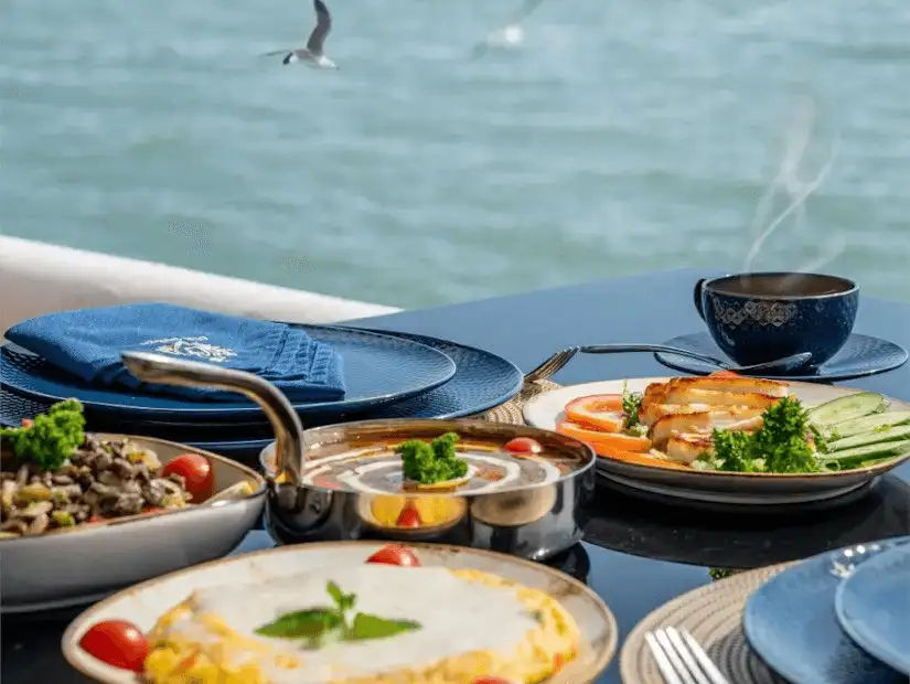 A serene dining setup with fresh dishes overlooking calm waters.