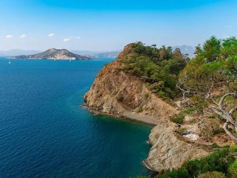 A picturesque island with rocky terrain and a vibrant blue sea surrounding it.