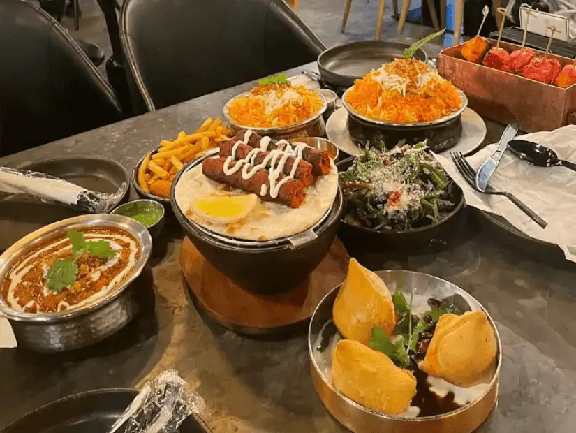 A colorful spread of dishes with rice, kebabs, and a variety of savory sides.