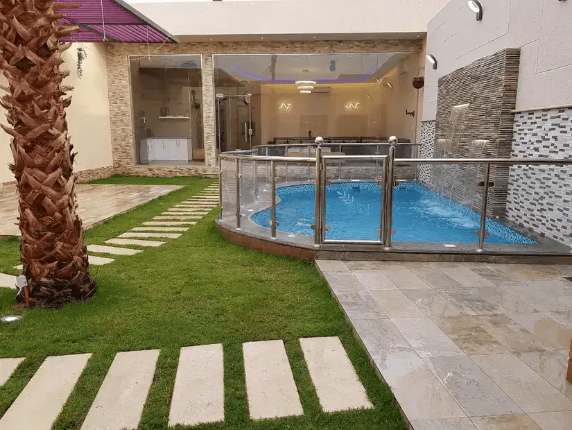 A luxurious chalet with a private pool surrounded by greenery and modern architecture.