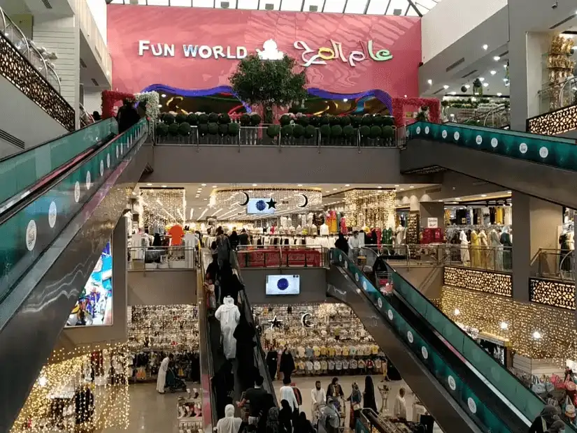 Manar Mall entrance featuring colorful decorative patterns and a palm tree.