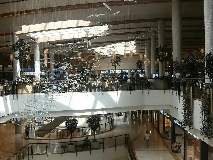 A cafe-filled atrium inside a spacious shopping center offers a place for rest and relaxation.