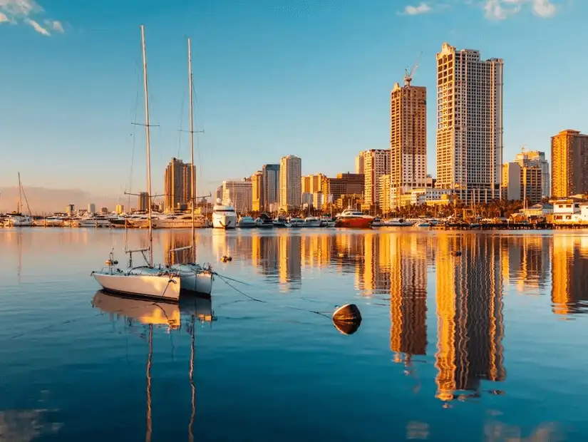 Manila Bay skyline with high-rise buildings and yachts.